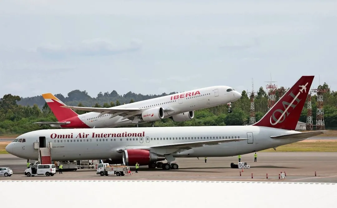 El avión de la selección de Irak permanece en tierra mientras despega el avión de la selección española que llevará al equipo antes de que embarquen en el aeropuerto de Santiago de Compostela este viernes. La selección masculina de fútbol viaja este viernes a las 10.00 horas rumbo a Chattanooga, en el estado de Tennessee (EE.UU.), donde estará su cuartel general durante el Mundial 2026. Lavandeira Jr/EFE
