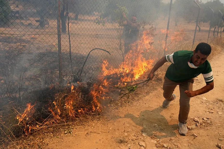 Residentes tratan de apagar las llamas de un incendio cerca de  San Martin de Valdeiglesias, al oeste de Madrid.  FOTO: CESAR MANSO. AFP