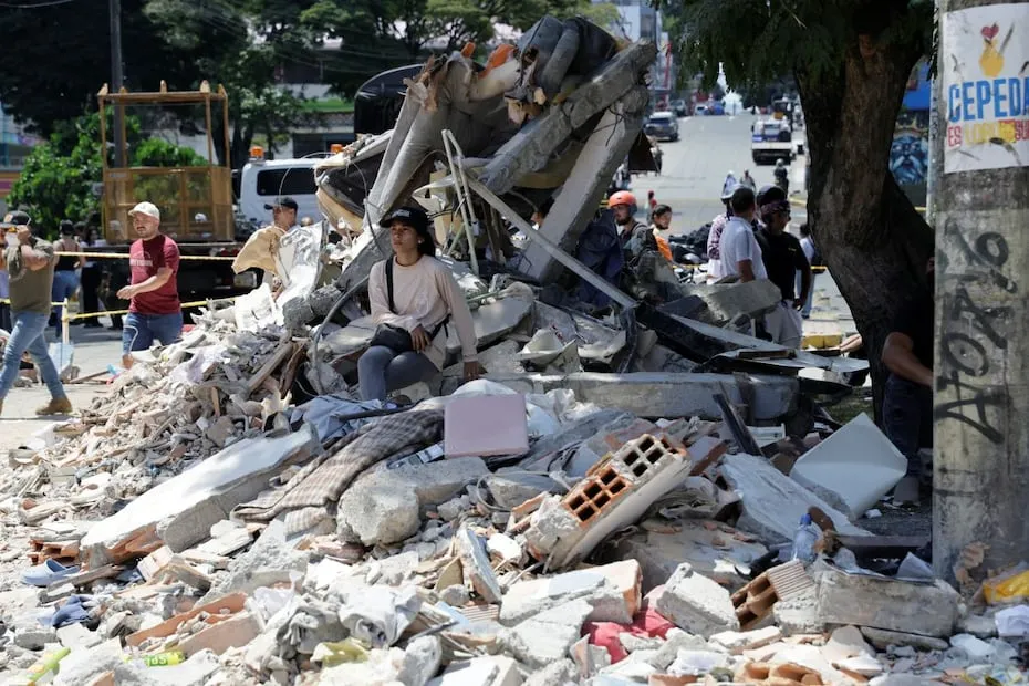 Una mujer espera entre los escombros de un edificio en Pereira, tras el terremoto de magnitud 7.4 que sacudió el lunes la mayor parte de Colombia. FOTO: CARLOS ORTEGA. EFE