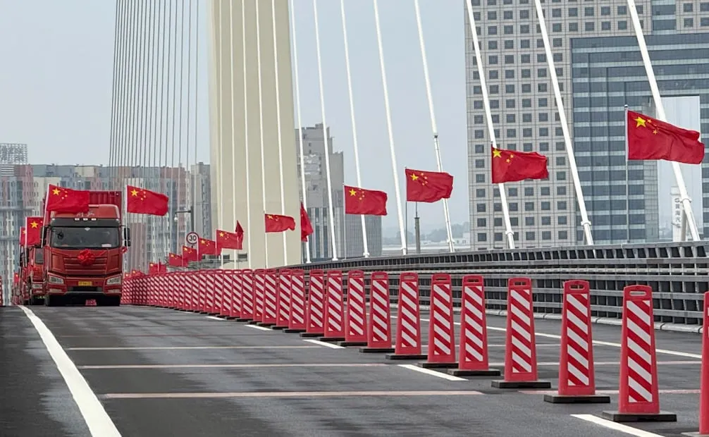 Camiones recorren el puente por primera vez durante la inauguración del puente. Foto: Pan Yulong/Xinhua via AP