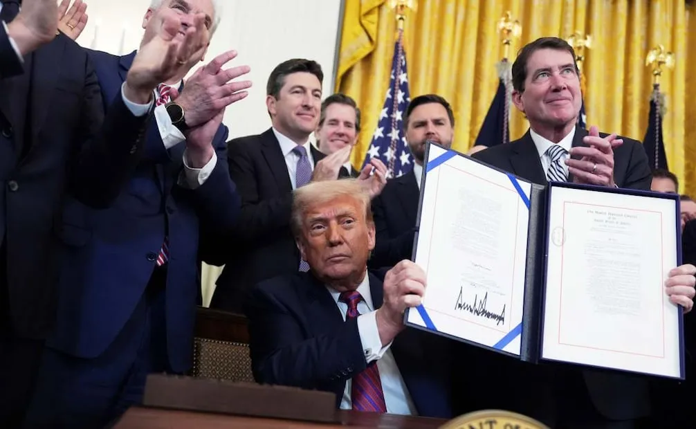 El presidente Donald Trump muestra la promulgación de la Ley GENIUS que regula las stablecoins, un tipo de criptomoneda, en la Sala Este de la Casa Blanca, el 18 de julio de 2025, en Washington. Foto: AP