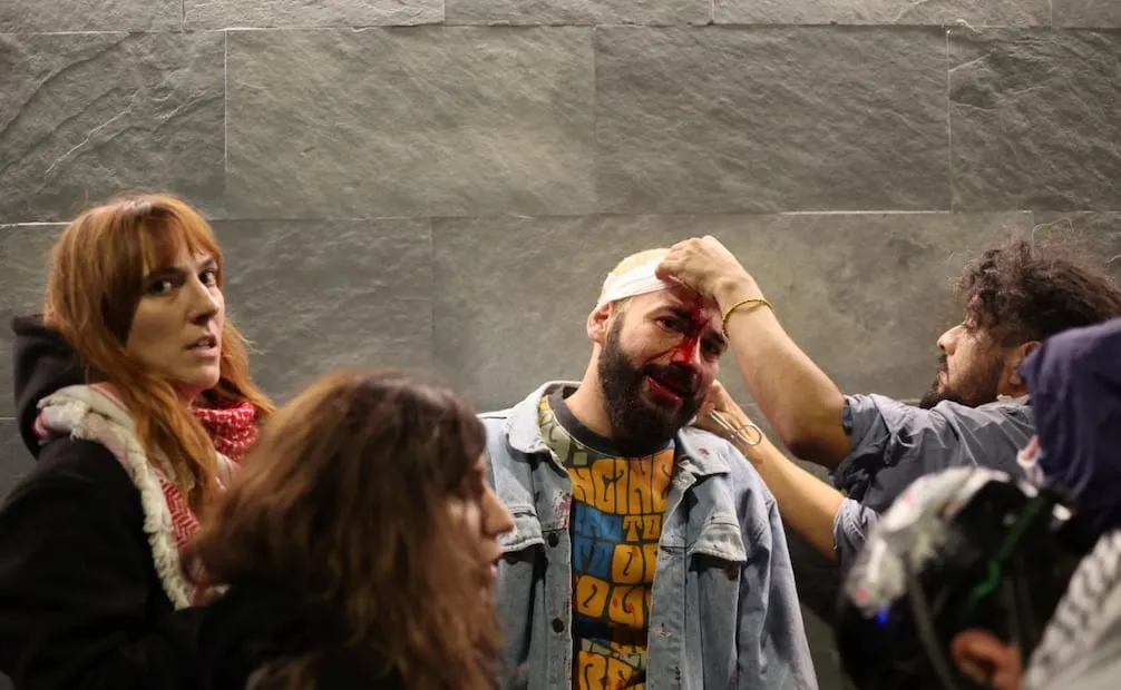 Un manifestante herido recibe atención médica durante una protesta del «Movimiento del 17 de Octubre» en Bolonia, Italia. Foto: EFE