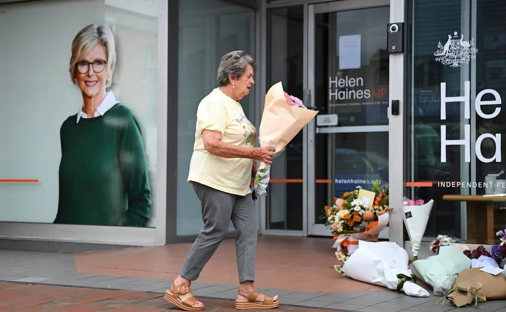 Mujer deja flores para Helen Haines afuera de su lugar de trabajo. (19/10/26) Foto: AP