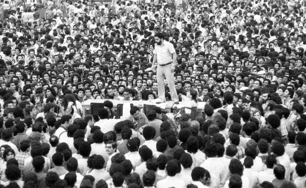 Lula se dirige a los metalúrgicos desde lo alto de una mesa en el estadio Vila Euclides, en São Bernardo do Campo, durante una asamblea que decidió iniciar la huelga en 1968. (25/10/26) Foto: Instituto Lula
