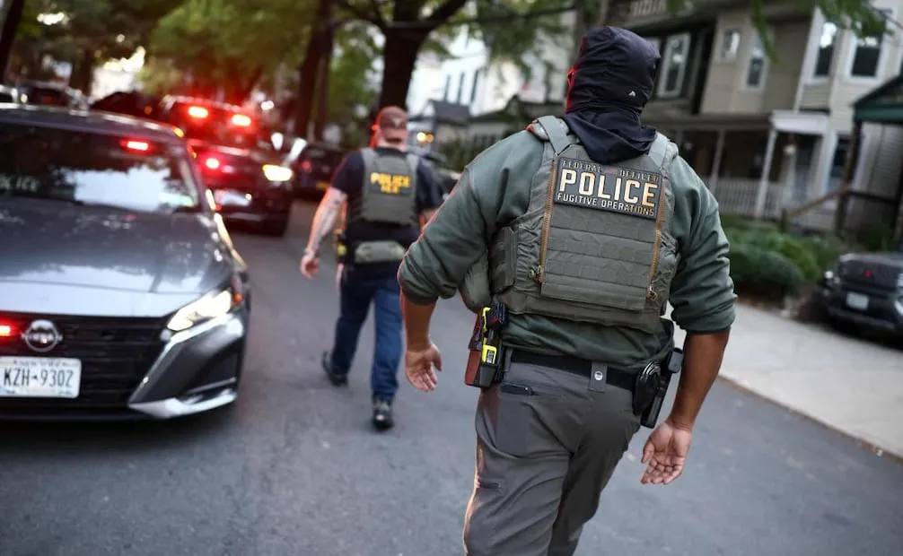 Cuerpo de policías camina cerca de la escena donde un agente de ICE disparó a un inmigrantes dominicano. (08/10/26) Foto: AFP